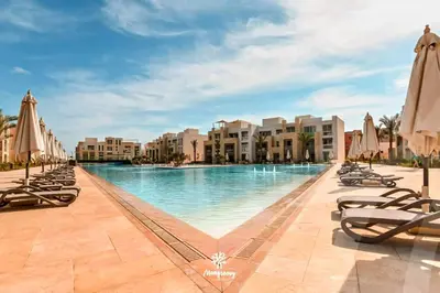 a pool at the resort with chaises and umbrellas at Luxury Stays in Mangroovy El Gouna in Hurghada