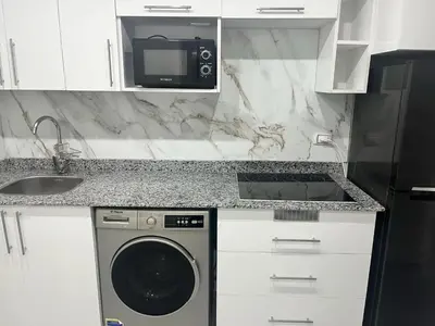 a kitchen with a washing machine and a microwave at scandic resort in Hurghada