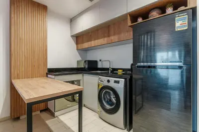 a kitchen with a washing machine and a table at Al Saraya Sahl Hasheesh by Peaks in Hurghada
