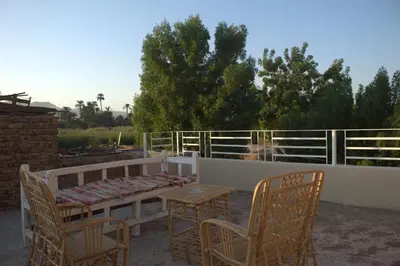 a patio with a table and chairs and a fence at AL Farida Guest House in Jazīrat al ‘Awwāmīyah