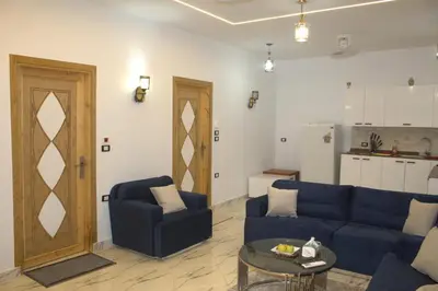 a living room with a blue couch and a table at AL Farida Guest House in Jazīrat al ‘Awwāmīyah