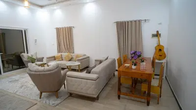 a living room with a couch and a table and a guitar at hodhod luxor in Al Qurnah