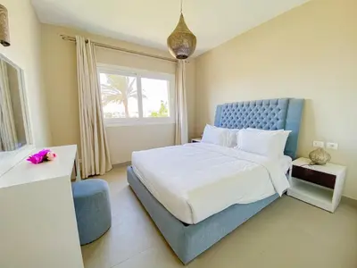 a bedroom with a large bed and a window at Nayah Stays, Joubal Lagoons flowery apartment in Hurghada