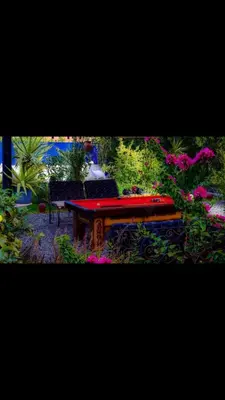 a table and chairs in a garden with flowers at منتجع لاكشيري جميع الرفاهيات و الكماليات in Hurghada