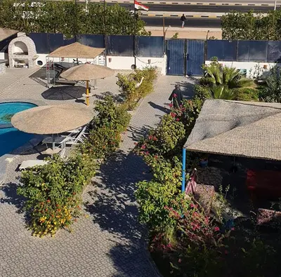 a garden with umbrellas and flowers and a swimming pool at منتجع لاكشيري جميع الرفاهيات و الكماليات in Hurghada