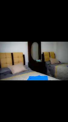 a bedroom with two beds and a mirror at منتجع لاكشيري جميع الرفاهيات و الكماليات in Hurghada