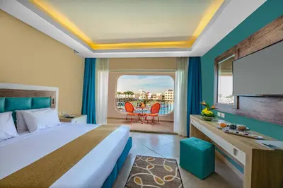 a hotel room with a bed and a balcony at Titanic Aqua Park Resort - Families and Couples only in Hurghada