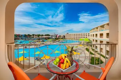 a balcony with a table with fruit and a view of a pool at Titanic Aqua Park Resort - Families and Couples only in Hurghada