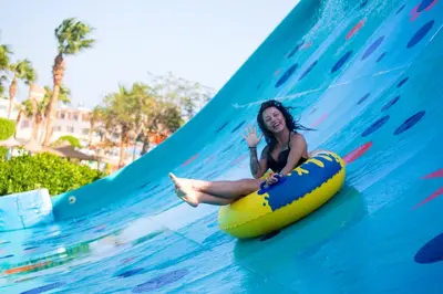 a woman is riding on a wave ride at a water park at Titanic Aqua Park Resort - Families and Couples only in Hurghada