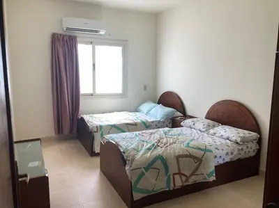 a hotel room with two beds and a window at Lovely flat with balcony and shared pool in Hurghada