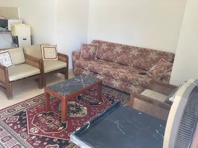 a living room with a couch and two chairs at Lovely flat with balcony and shared pool in Hurghada