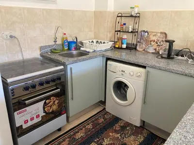 a kitchen with a sink and a washing machine at Lovely flat with balcony and shared pool in Hurghada