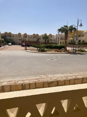 an empty street with buildings in the background and a fence at Lovely flat with balcony and shared pool in Hurghada