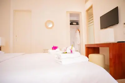 a bedroom with a white bed with towels on it at Nayah Stays, Ancient Sands Luxurious Pool Terrace Apartment in Hurghada