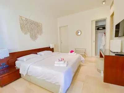 a bedroom with a large white bed with flowers on it at Nayah Stays, Ancient Sands Luxurious Pool Terrace Apartment in Hurghada