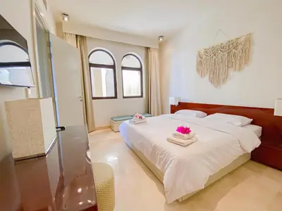 a bedroom with a bed with pink flowers on it at Nayah Stays, Ancient Sands Luxurious Pool Terrace Apartment in Hurghada