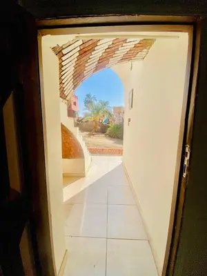 an open door to a hallway with an archway at Dangy Kato in Aswan