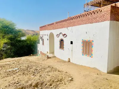 a small white building on a dirt road at Dangy Kato in Aswan