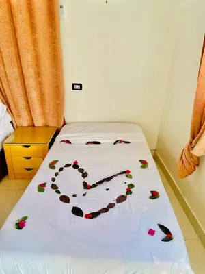 a bed with flowers on it in a room at Dangy Kato in Aswan