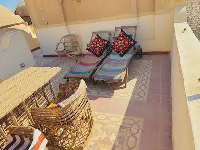a balcony with chairs and a bench and a table at King Tut in Luxor