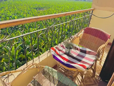 a table and chairs on a balcony with a green field at King Tut in Luxor