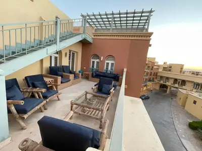 a balcony of a building with blue chairs and a staircase at Apartment for rent in ElGouna in Hurghada