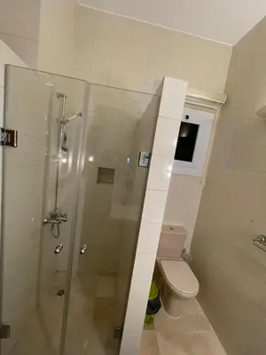 a bathroom with a toilet and a glass shower at Apartment for rent in ElGouna in Hurghada