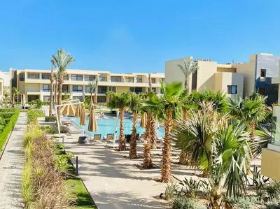 a resort with palm trees and a swimming pool at Sunny 1 BR Apt G cribs ElGouna with open View in Hurghada
