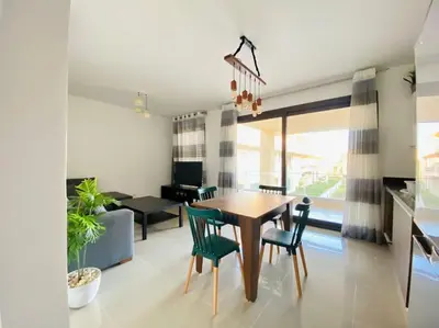 a dining room and living room with a table and chairs at Sunny 1 BR Apt G cribs ElGouna with open View in Hurghada
