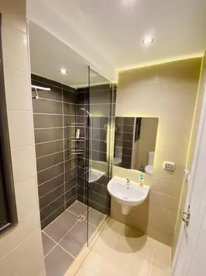 a bathroom with a shower with a sink and a shower at Sunny 1 BR Apt G cribs ElGouna with open View in Hurghada