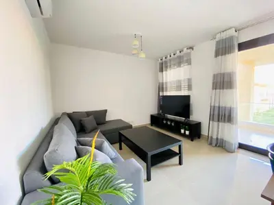 a living room with a couch and a table at Sunny 1 BR Apt G cribs ElGouna with open View in Hurghada