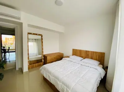 a bedroom with a large bed and a mirror at Sunny 1 BR Apt G cribs ElGouna with open View in Hurghada