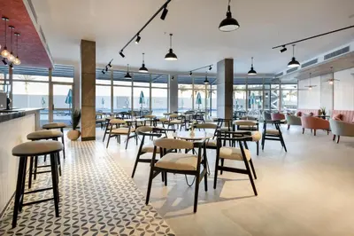 a restaurant with tables and chairs and windows at Flow Spectrum Resort Sahl Hasheesh in Hurghada
