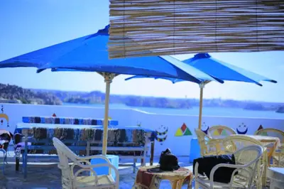 a couple of blue umbrellas and tables and chairs at dahab in Aswan