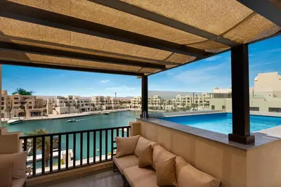 a balcony with a view of a pool and buildings at Fanadir Marina Front Penthouse with Pool in Hurghada