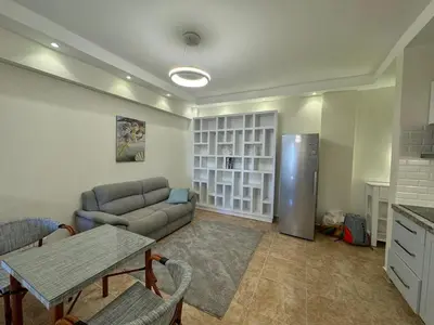 a living room with a couch and a refrigerator at A one-bedroom apartment with a compact terrace in Hurghada