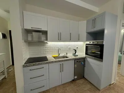 a kitchen with white cabinets and a sink at A one-bedroom apartment with a compact terrace in Hurghada