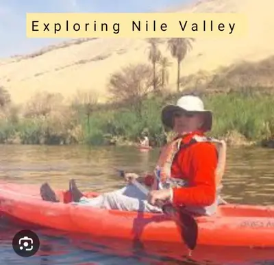 a man sitting in a red kayak on the water at Nile Kaiak Adventure in Aswan