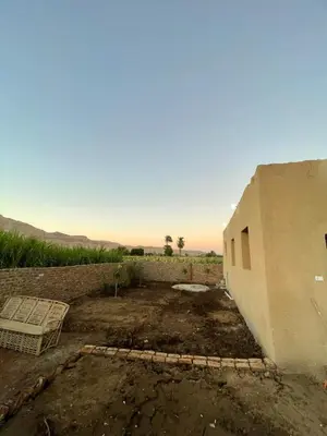 a building in the middle of a dirt field at Habu flower in Al Aqālitah