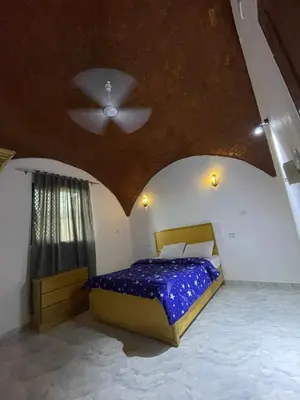 a bedroom with a bed and a ceiling at Habu flower in Al Aqālitah