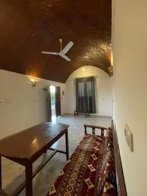a living room with a ceiling fan and a couch at Habu flower in Al Aqālitah