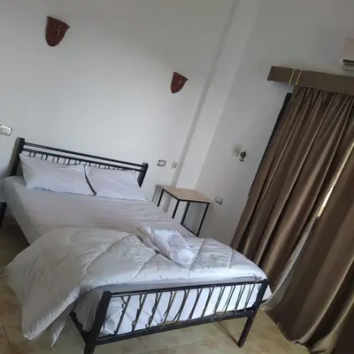a bedroom with a bed with white sheets at Villa River Nile in Al Qurnah