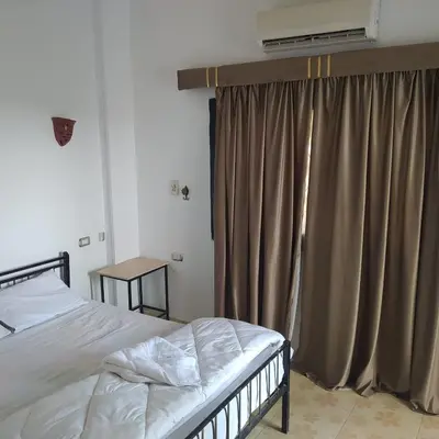 a bedroom with a bed and a window with curtains at Villa River Nile in Al Qurnah