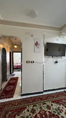 a room with a white wall with a flat screen tv at Aswan apartment-Center of Aswan in Aswan