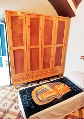 a wooden cabinet in a room with a rug on the floor at Ibiza Guest House in Aswan