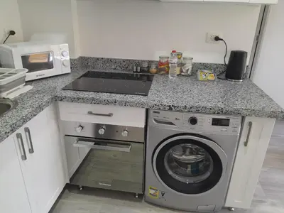 a kitchen with a washing machine and a microwave at Spacious and modern one bed in hurhgarda in Hurghada