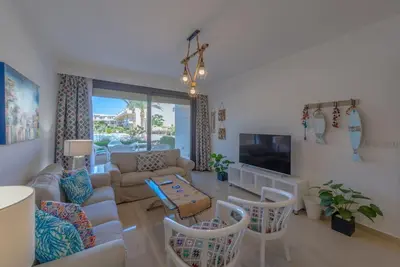 a living room with a couch and a tv at Chic 2 BR poolside Apartment at G-crib El Gouna in Hurghada