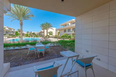 a patio with tables and chairs and a pool at Chic 2 BR poolside Apartment at G-crib El Gouna in Hurghada