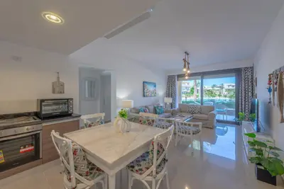 a kitchen and living room with a table and chairs at Chic 2 BR poolside Apartment at G-crib El Gouna in Hurghada