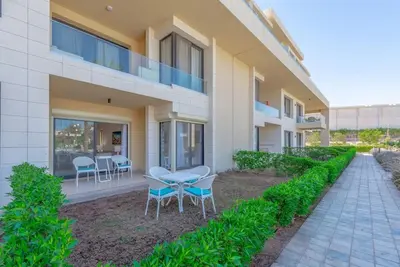 a building with a patio with chairs and a table at Chic 2 BR poolside Apartment at G-crib El Gouna in Hurghada